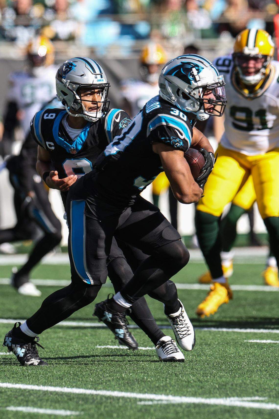 Carolina Panthers quarterback Bryce Young (9) hands the ball to running back Chuba Hubbard (30) during the game at Bank of America Stadium on Sunday, December 24, 2023.