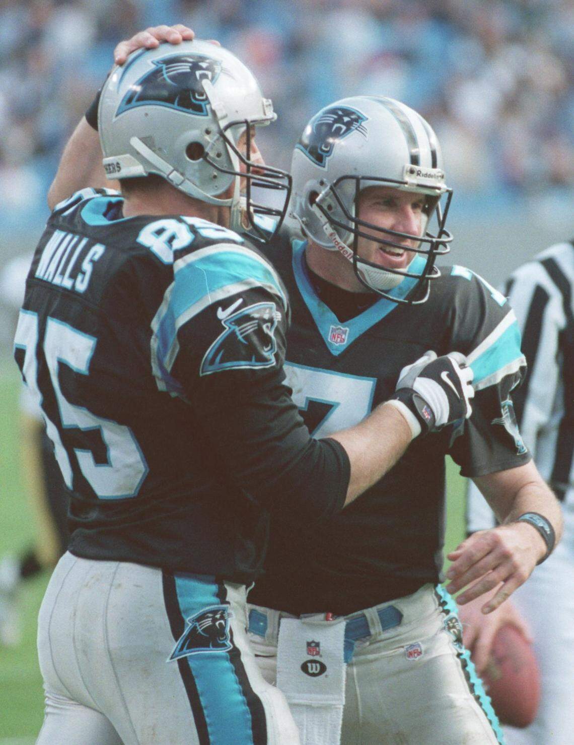 In the final game of the 1999 season, Carolina Panthers quarterback (7) Steve Beuerlein congratulates teammate Wesley Walls Sunday after Walls caught a touchdown pass to tie an NFL record for touchdown receptions by a tight end in a single season (12).