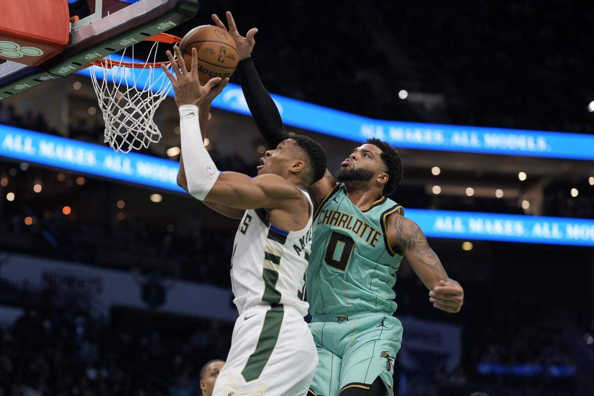 Nov 16, 2024; Charlotte, North Carolina, USA; Charlotte Hornets forward Miles Bridges (0) blocks a shot by Milwaukee Bucks forward Giannis Antetokounmpo (34) during the second quarter at Spectrum Center. Mandatory Credit: Jim Dedmon-Imagn Images