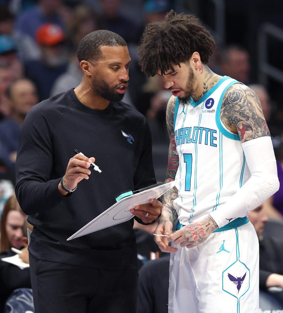 Charlotte Hornets head coach Charles Lee, left, speaks with guard LaMelo Ball, right, prior to the team’s game against the New Orleans Pelicans at Spectrum Center in Charlotte, NC on Monday, February 2, 2026. Ball and Lee would collide during action and Ball would leave the floor temporarily to receive medical aid.