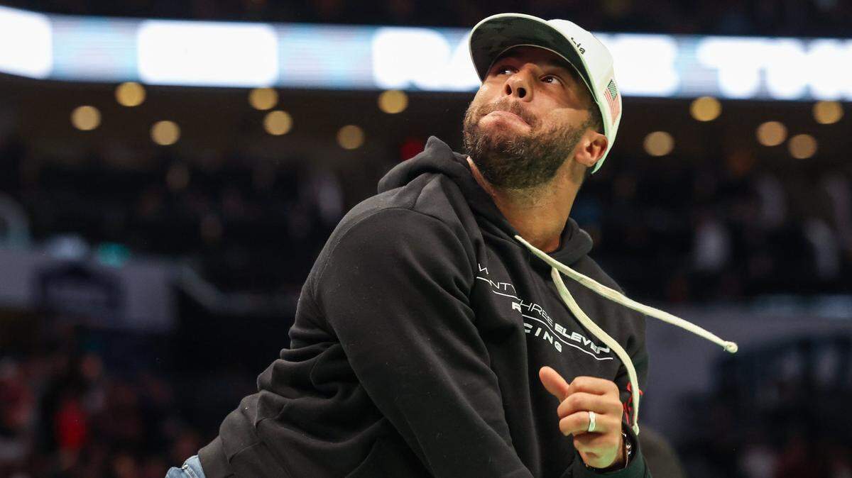 Bubba Wallace helps throw free t-shirts into the stands during a timeout at the game between the Hornets and the Bulls at Spectrum Center on Thursday, January 26, 2023. Wallace was in attendance with fellow 23XI Racing teammates, Kurt Busch and Tyler Reddick.