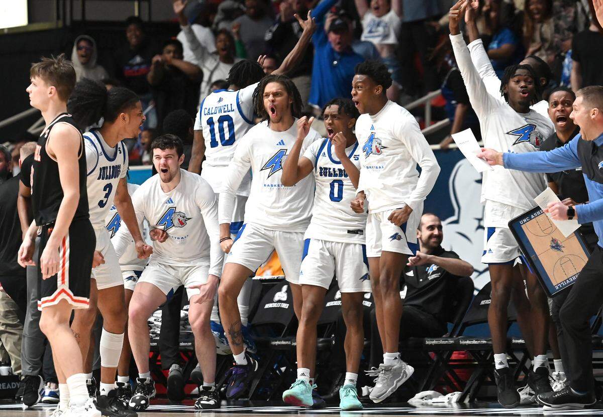 The UNC Asheville bench erupts after a three-point basket by guard Tajion Jones, left, during second half action against Campbell in the 2023 Hercules Tires Big South Men’s Basketball Championship game on Sunday, March 5, 2023 at Bojangles Coliseum in Charlotte, NC. UNC Asheville defeated Campbell 77-73, with Jones scoring 24 points and the go-ahead basket.