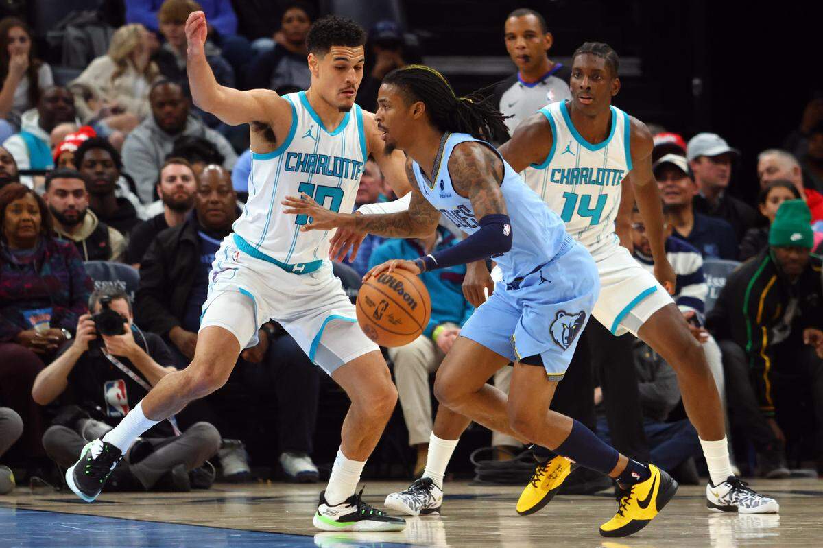 Memphis Grizzlies guard Ja Morant (12) drives to the basket as Charlotte Hornets guard Josh Green (10) defends during Wednesday’s second quarter at FedExForum. Petre Thomas-Imagn Images