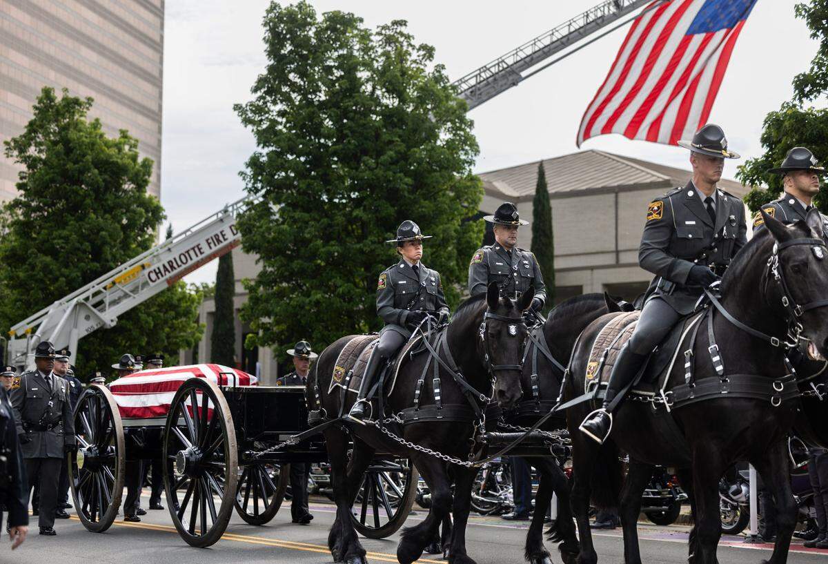 A horse-drawn carriage carries the body of officer Joshua Eyer to First Baptist Church on Friday, May3, 2024. Officer Eyer was killed while serving a warrant in east Charlotte on Monday, April 29, 2024
