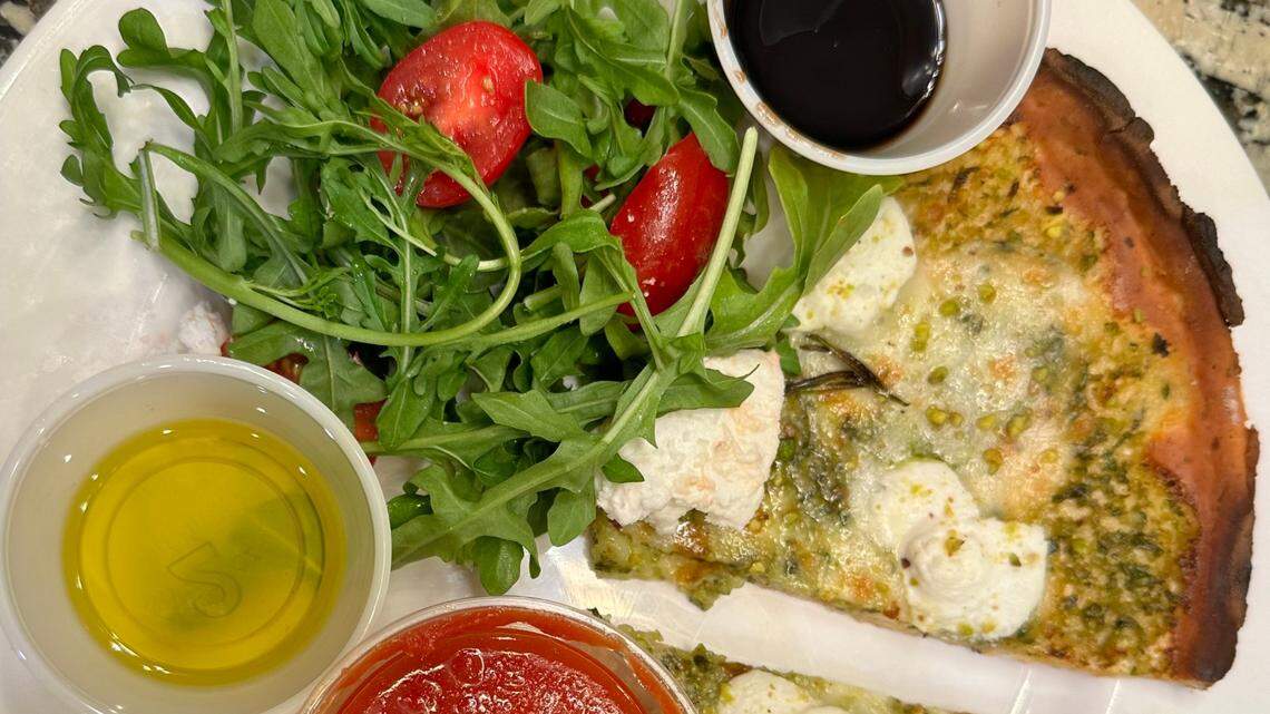 Inizio’s pistachio pizza cooked on a cauliflower crust and served alongside an arugula salad.