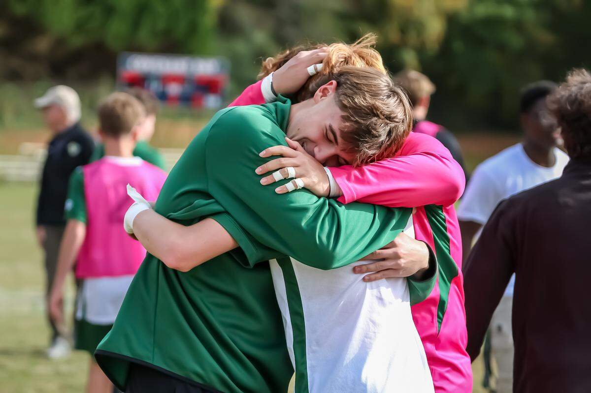 Christ School players embrace after the Greenies beat Covenant Day, 2-1, for the NCISAA boys’ soccer state championship at Covenant Day School.