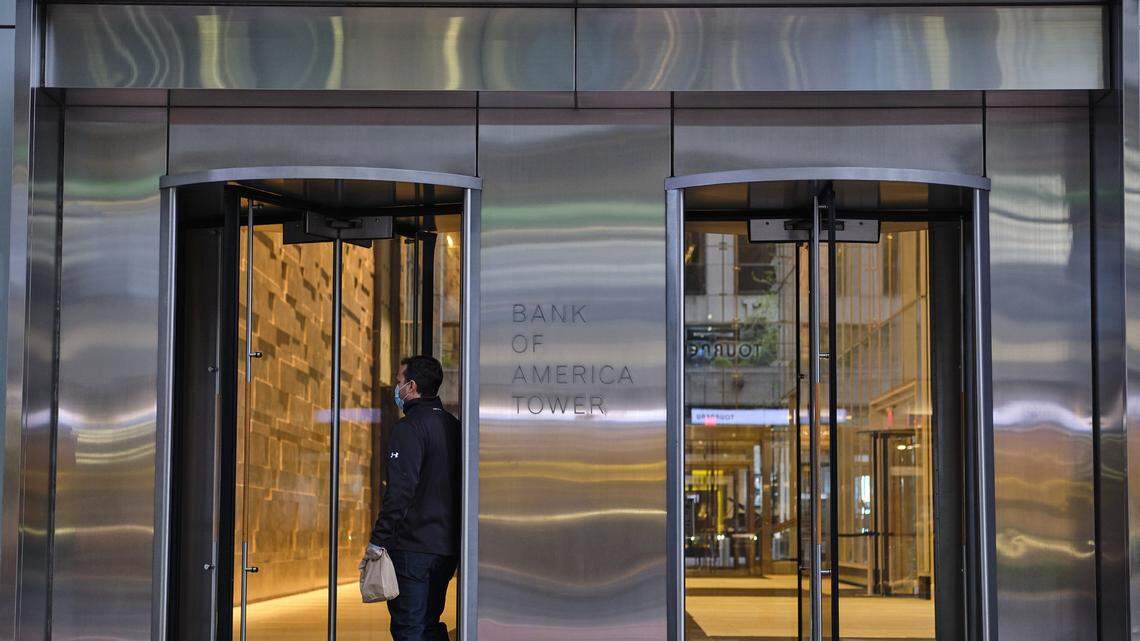 A masked worker enters Bank of America’s offices in Manhattan, April 9, 2020. A New York executive at the bank was arrested on bribery charges in October.