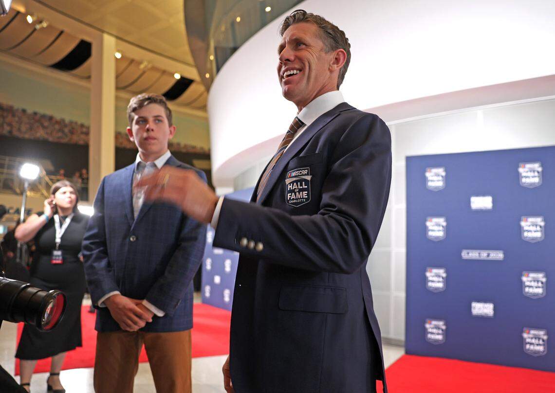 Former NASCAR driver Carl Edwards speaks with friends along the red carpet at the NASCAR Hall of Fame on Friday, January 23, 2026. At left, is Edwards' son Michael.