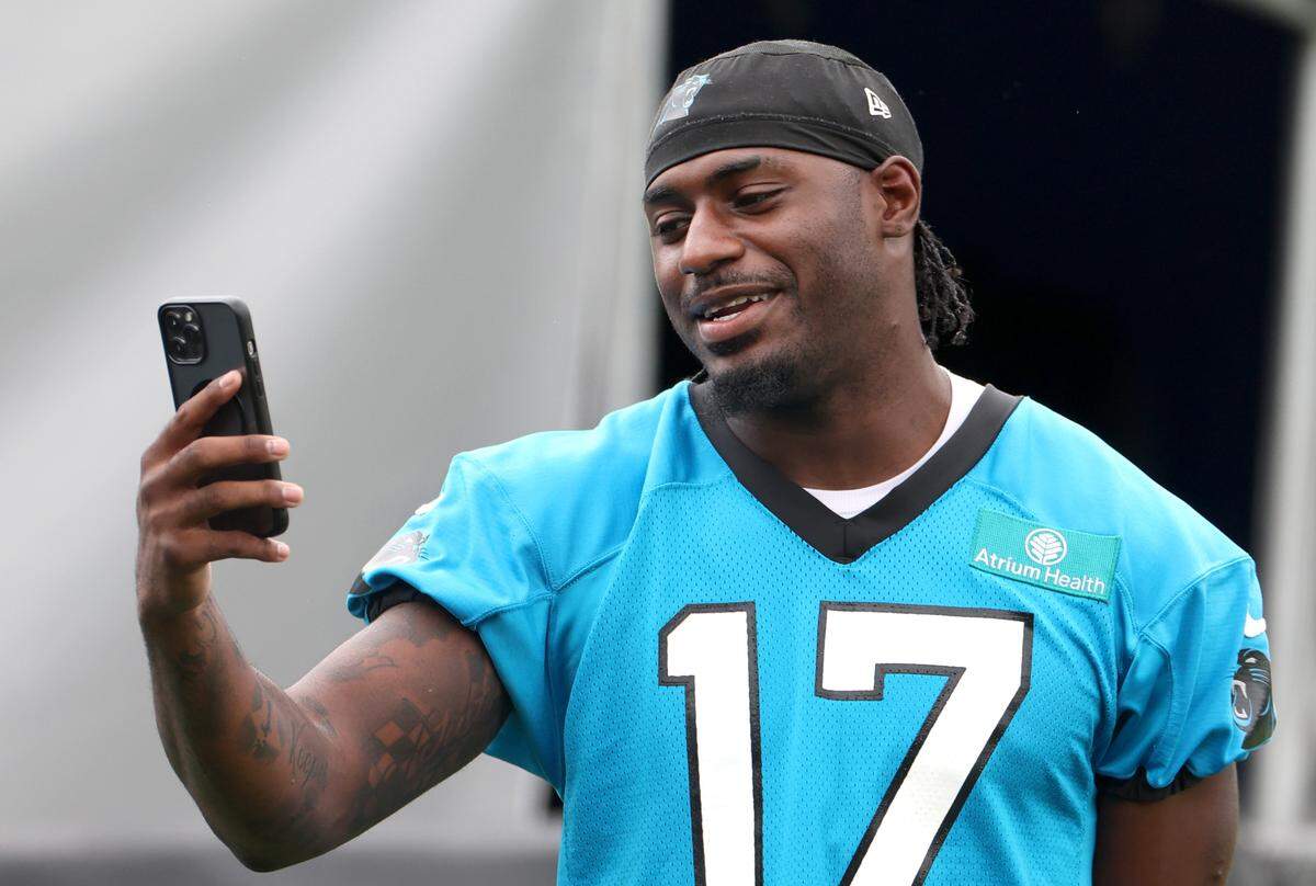 Carolina Panthers wide receiver Xavier Legette has one last task to do on his i-phone prior to training camp practice on Thursday, July 25, 2024.