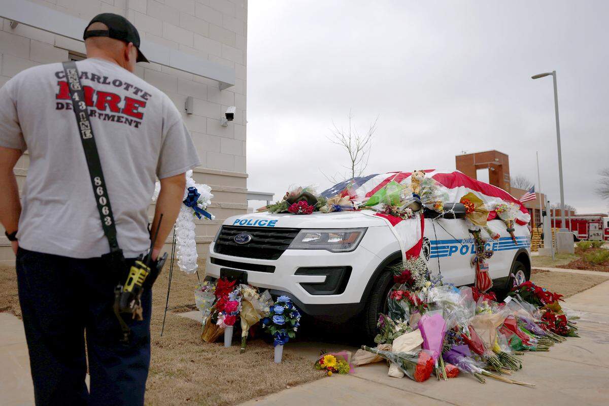 A member of the Charlotte Fire Department pays respect to fallen Charlotte-Mecklenburg Police officer Mia Goodwin on Tuesday, December 28, 2021 at the University City Police precinct. Officer Goodwin was killed while responding to a crash on Interstate 85.