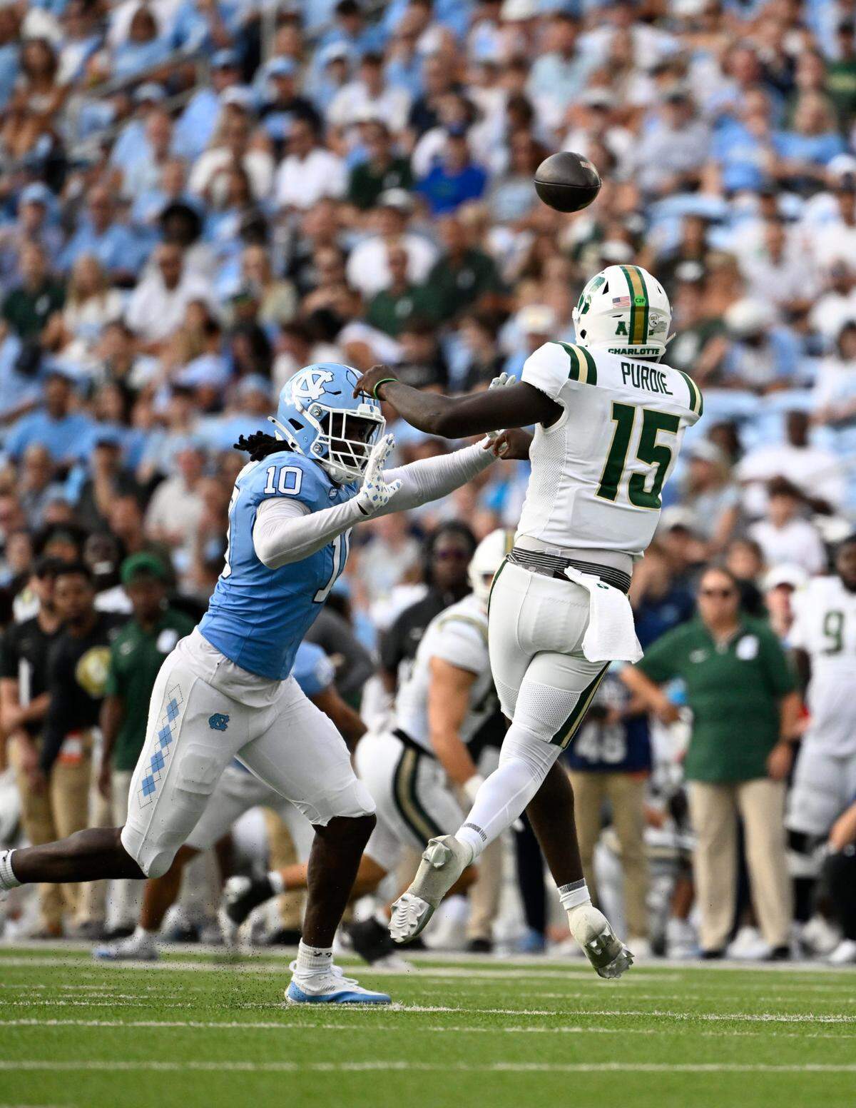 Charlotte 49ers quarterback Deshawn Purdie (15) passes the ball as North Carolina Tar Heels defensive lineman Desmond Evans (10) pressures in their Week 2 game. / Bob Donnan-Imagn Images