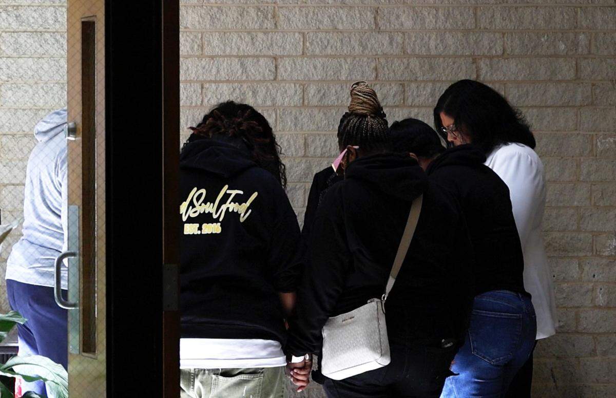 Attorney Saleisha Averhart (far right) prays with close friends and family members of Shanquella Robinson ahead of a press conference on Tuesday.
