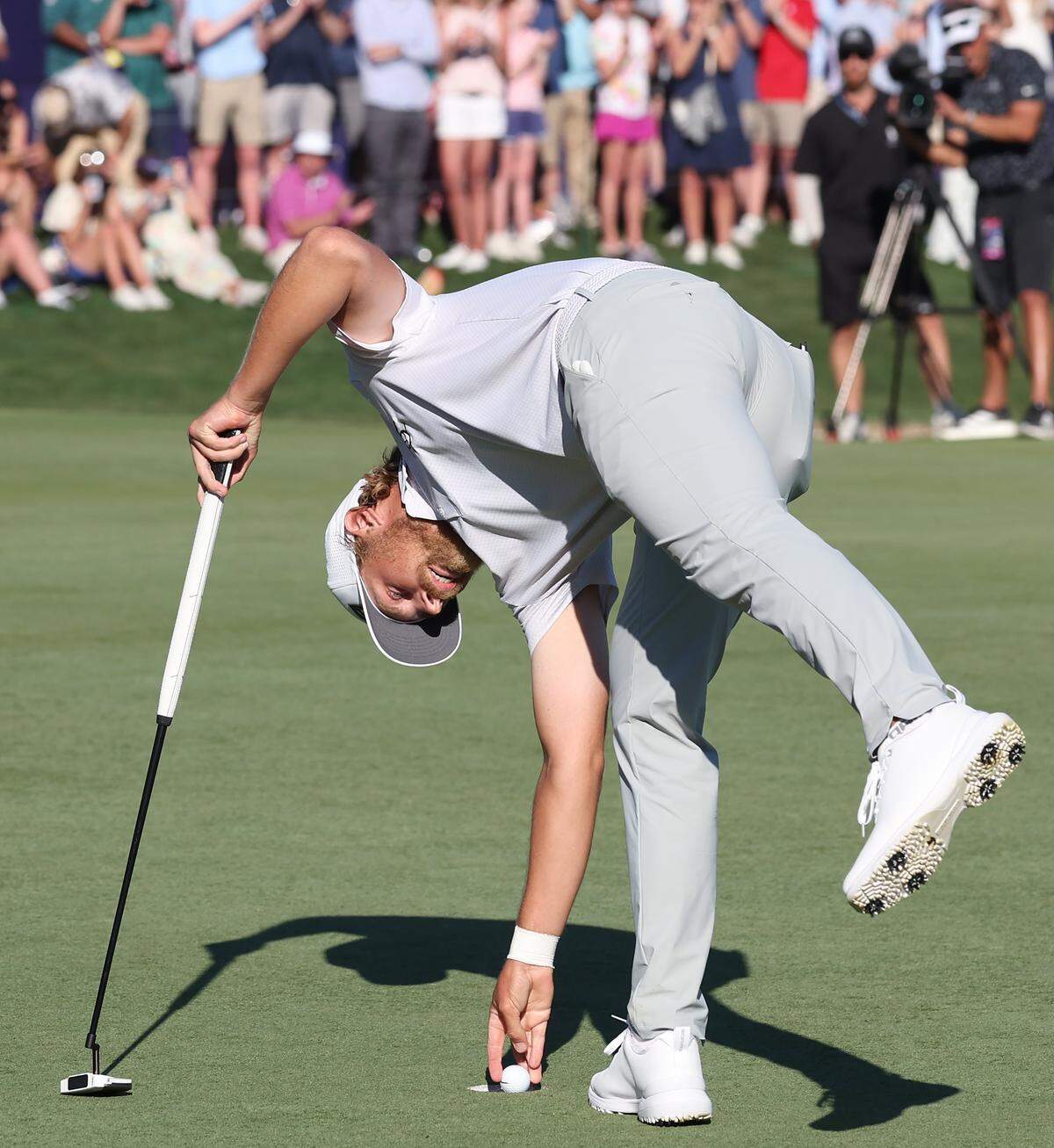 Golfer Kristoffer Reitan smiles as he pulls his ball from the cup to win the Truist Championship at Quail Hollow Club in Charlotte, NC on Sunday, May 10, 2026. Reitan won the Truist Championship finishing at -15.