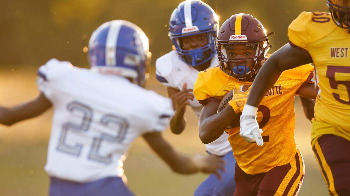 West Charlotte’s Scottie Cooper (2) runs the ball past Garinger’s Sincere Watson (22) during a game at Waddell High School in Charlotte, N.C., Thursday, Sept. 8, 2022. West Charlotte beat Garinger 48-8.