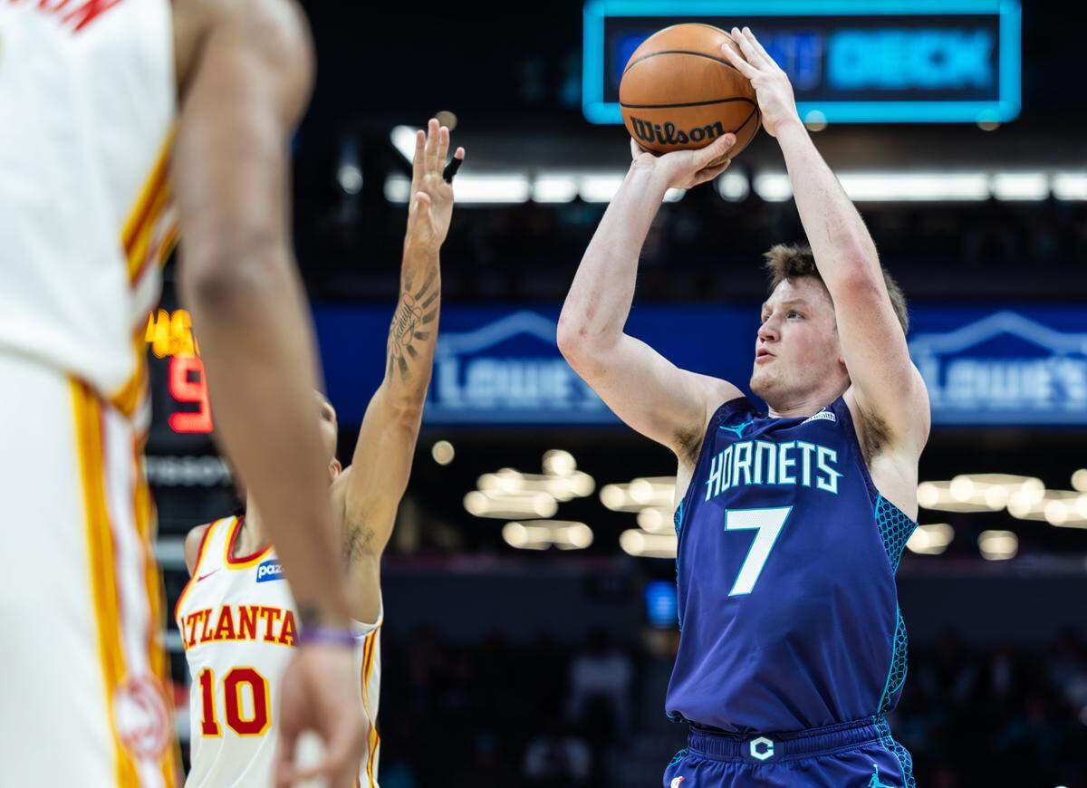Charlotte Hornets guard Kon Knueppel, right, shoots past a block by Atlanta Hawks forward Zaccharie Risacher at the Spectrum Center in Charlotte, N.C., on Wednesday, February 11, 2026.