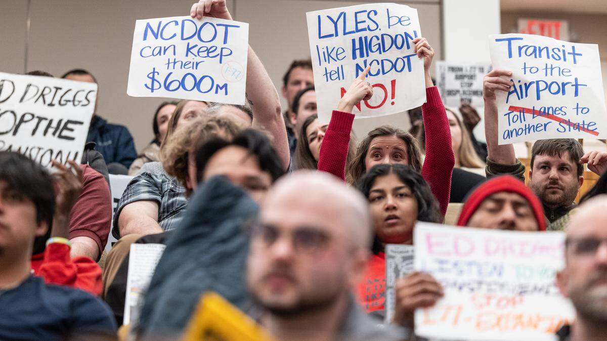 Residents concerned about the I-77 project hold up signs during the City Council meeting at the Charlotte-Mecklenburg Government Center in Charlotte, N.C., on Monday, February 23, 2026.