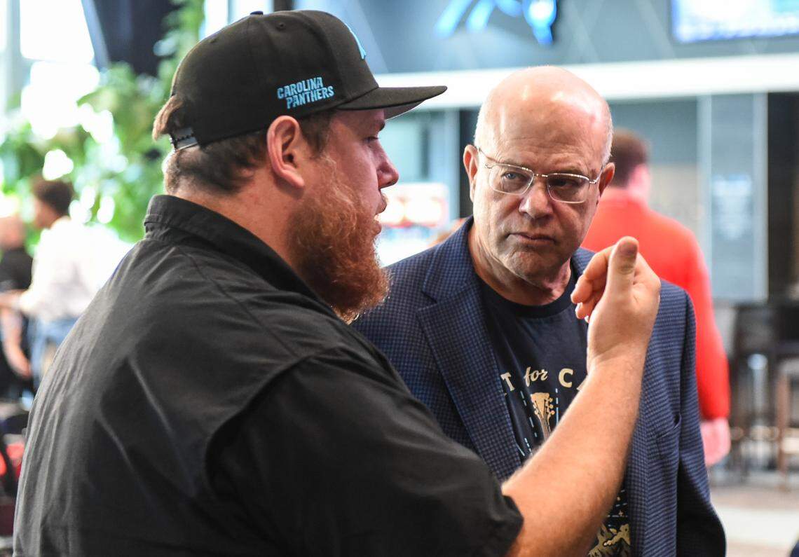 Country music star and Huntersville native, Luke Combs, left, speaks with David Tepper, founder of Tepper Sports and Entertainment, after a press conference for the Concert for Carolina taking place tonight at Bank of America Stadium in Charlotte. All proceeds from the concert will go to Hurricane Helene relief efforts in the Carolina region.
