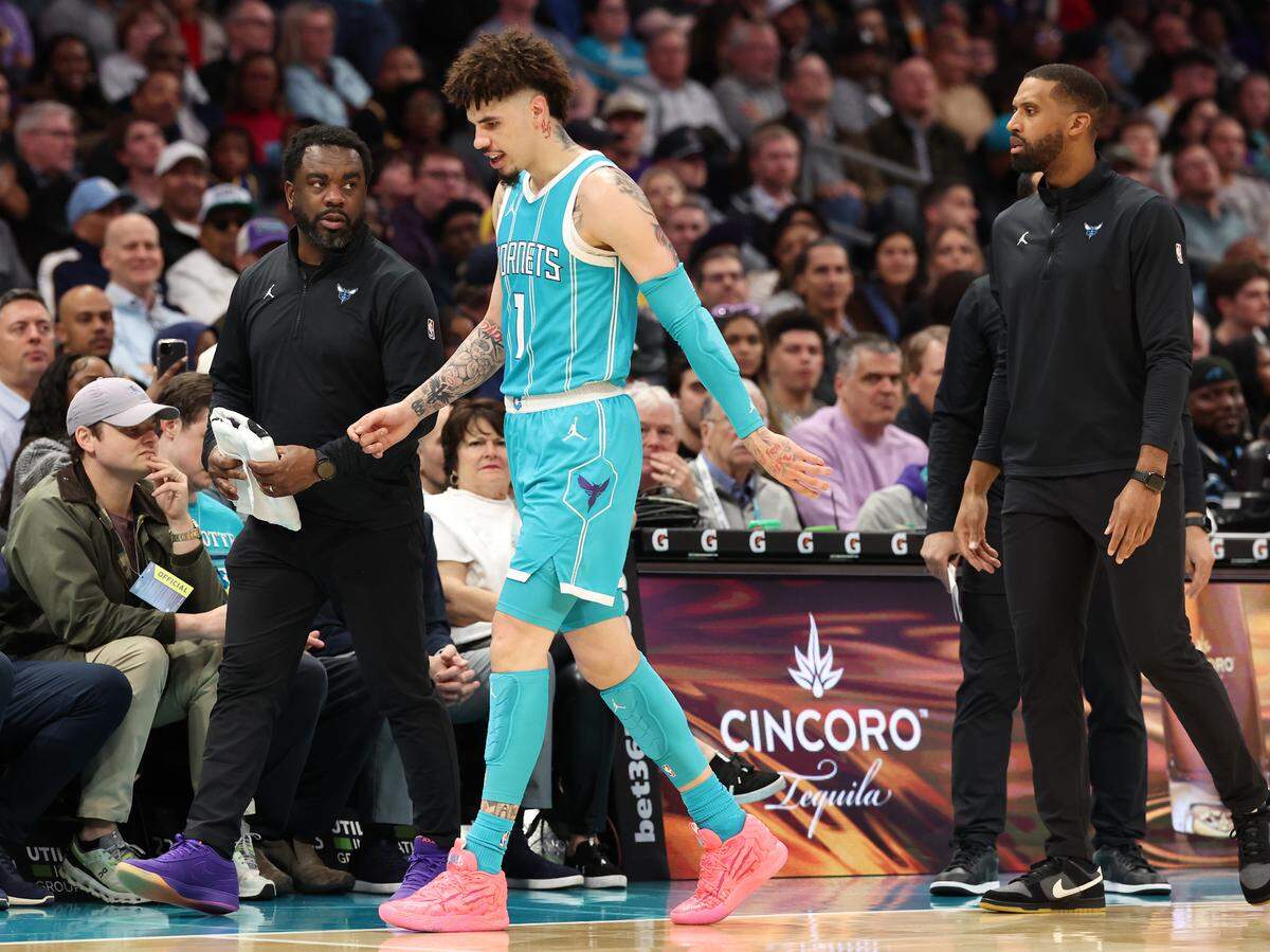 Charlotte Hornets guard LaMelo Ball, center, gingerly walks past the team’s bench to the locker room after falling to the court as he backpedaled downcourt. Ball tripped over Los Angeles Lakers forward Jarred Vanderbilt and leave the game with a sprained left ankle during action at Spectrum Center in Charlotte, NC on Monday, January 27, 2025.