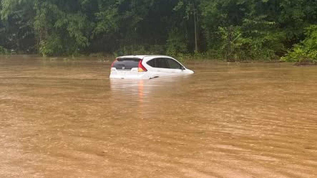 This photo released Saturday by the Union County Sheriff’s Office shows a car in floodwaters almost above its tires.