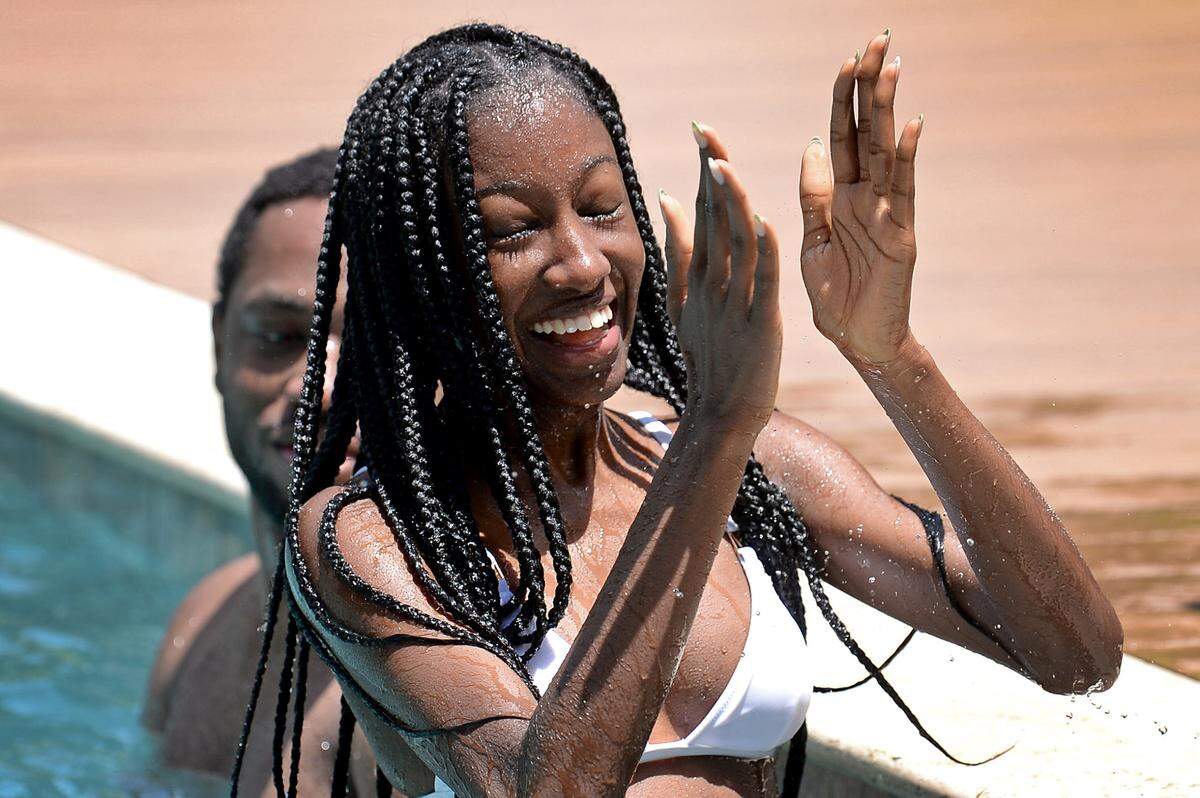 Samantha Flanigan claps as she enjoys an afternoon swim at a Charlotte home with Shane Richards, left, on Wednesday, July 14.