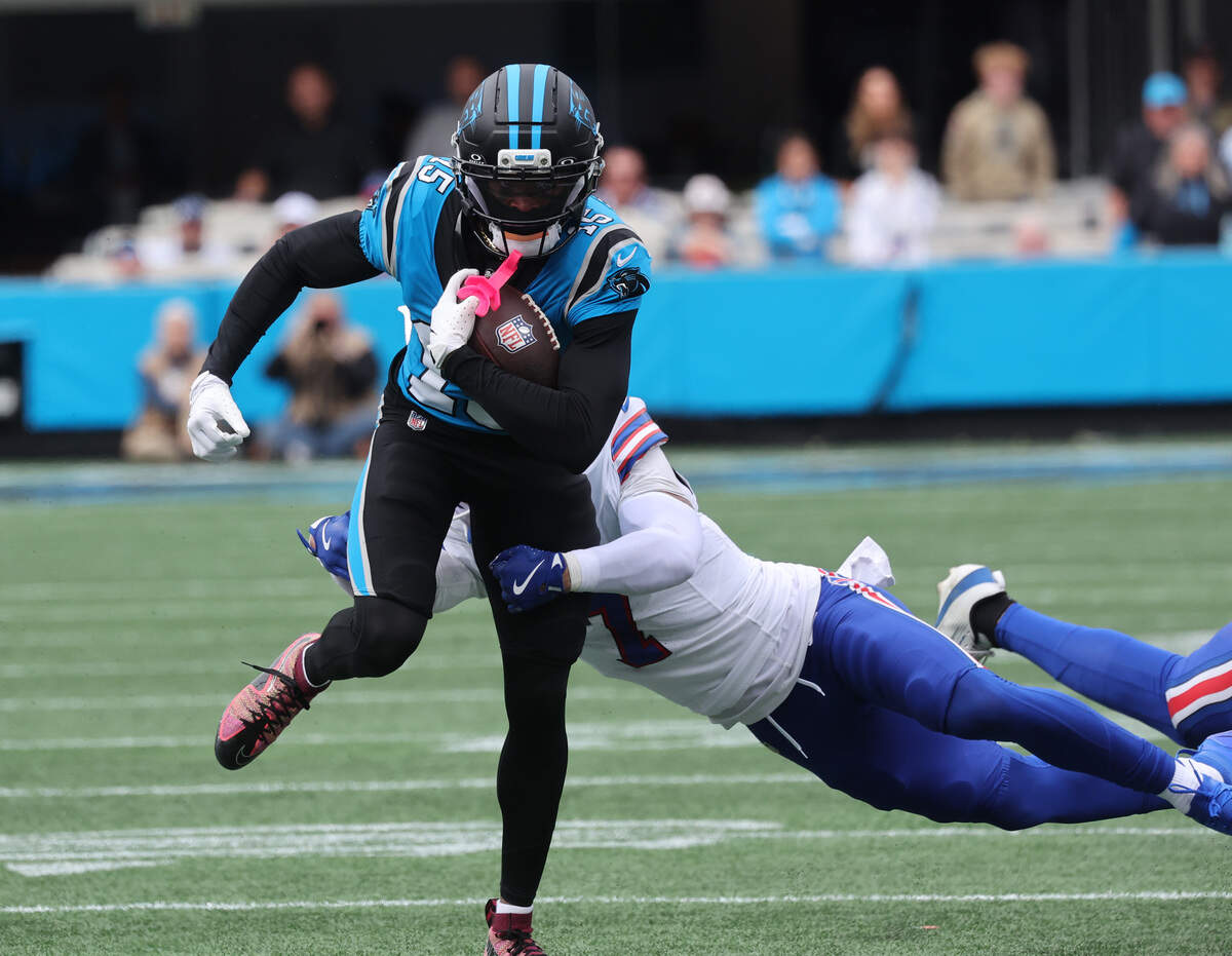 Carolina Panthers' Jimmy Horn Jr. carries the ball as Buffalo Bills' Taron Johnson tries to tackle him Sunday, Oct. 26, 2025 at Bank of America Stadium in Charlotte