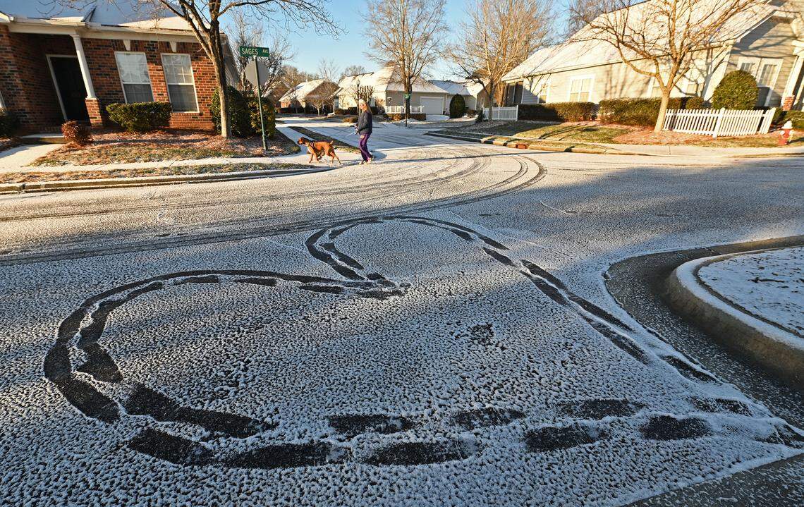 Holly Strack walks her dogs, Tyson and Benson past a heart created in the snow dusted street in the Village of Lake Park in Union County on Wednesday, January 22, 2025.