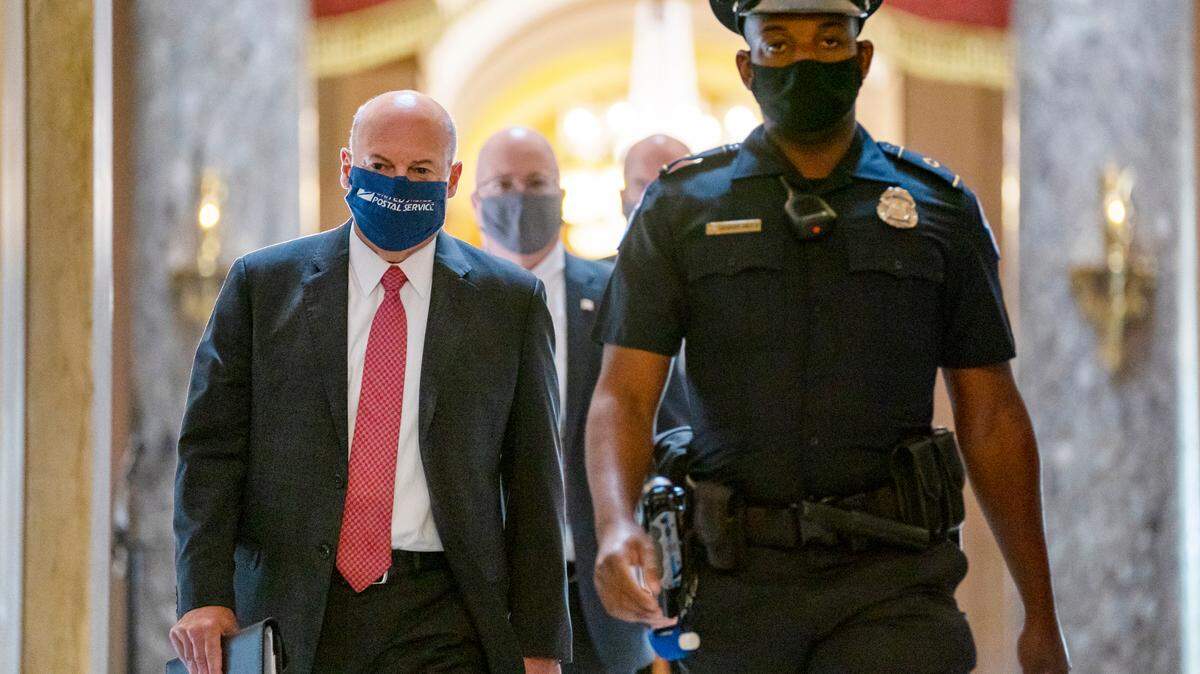 Postmaster General Louis DeJoy, left, is escorted to House Speaker Nancy Pelosi’s office on Capitol Hill in Washington, Wednesday, Aug. 5, 2020. DeJoy is a Greensboro businessman who is drawing fire for changes at the postal service that critics worry could delay delivery of absentee ballots this fall. (AP Photo/Carolyn Kaster)