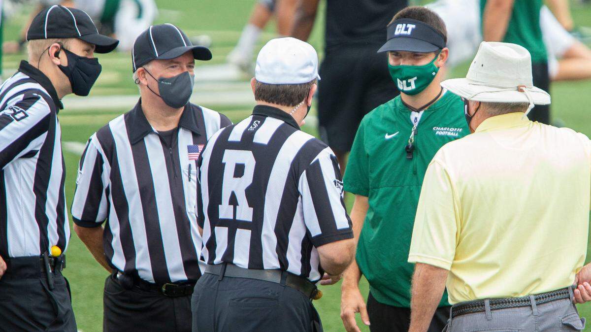 Charlotte 49ers coach Will Healy talks with the referees before the team scrimmage starts at Richardson Stadium on Saturday.