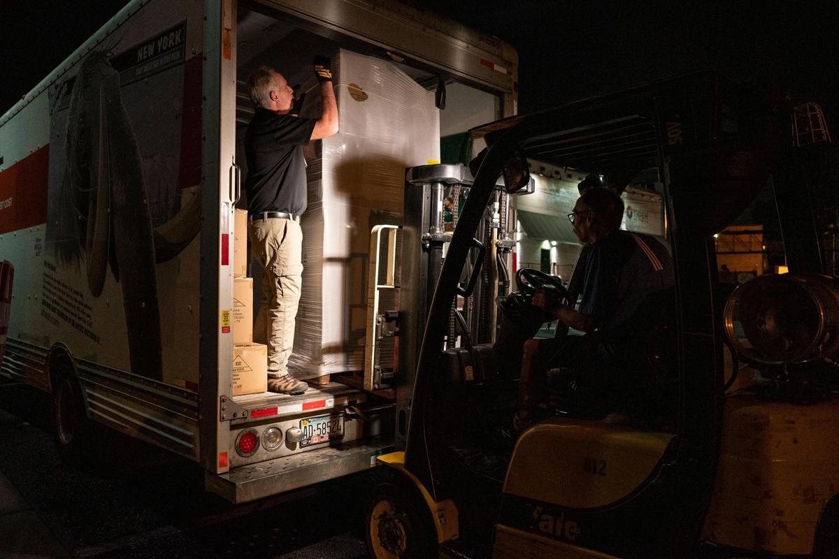 Tom Brotherton, left, and John Zimmerman work Friday morning unloading palettes of holiday decorations from a box truck at Blackhawk Hardware in Park Road Shopping Center. Store co-owner Andy Wilkerson rented two box trucks to pick up the order Thursday from the port in Savannah, Ga.