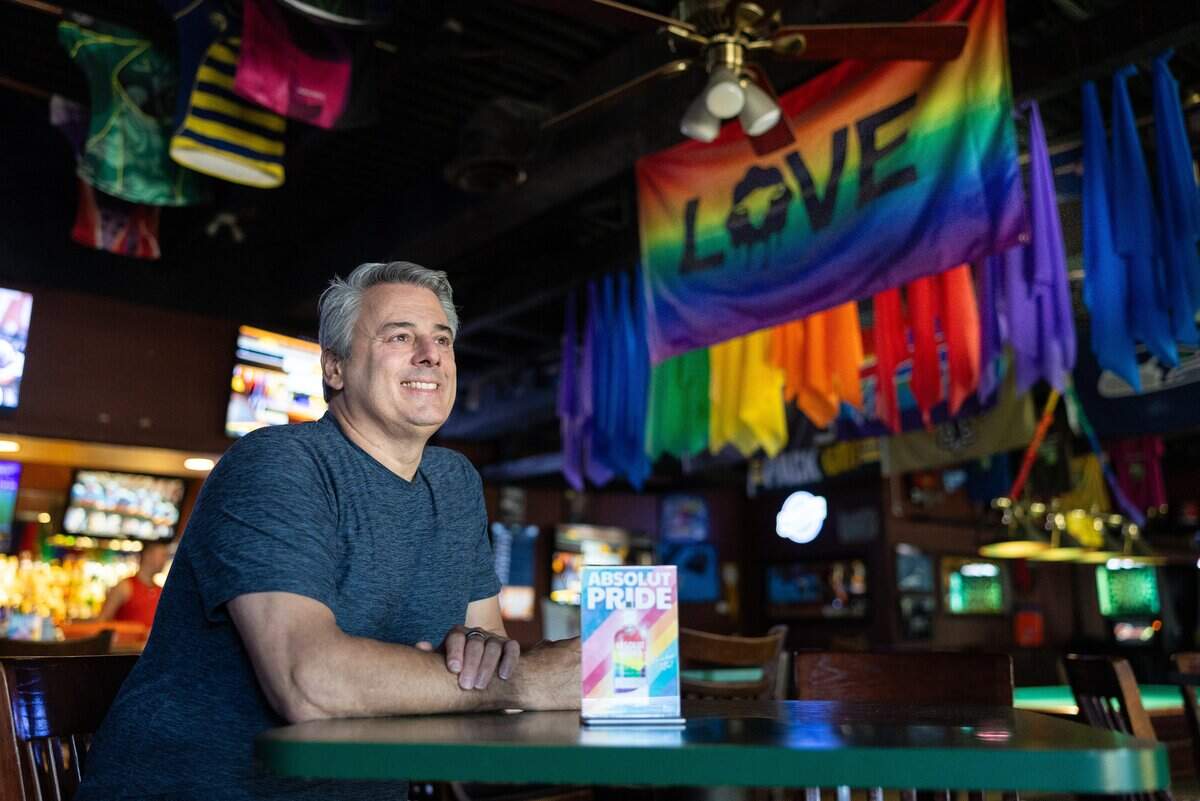 Bar owner Kevin Cooper poses for a portrait inside Sidelines.