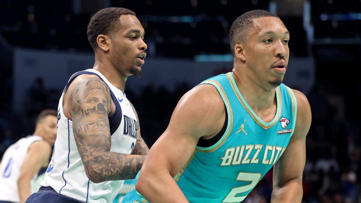 Dallas Mavericks forward P.J. Washington, left, applies defensive pressure on Charlotte Hornets forward Grant Williams, right, during first-half action on Tuesday, April 9, 2024 at Spectrum Center in Charlotte, NC.