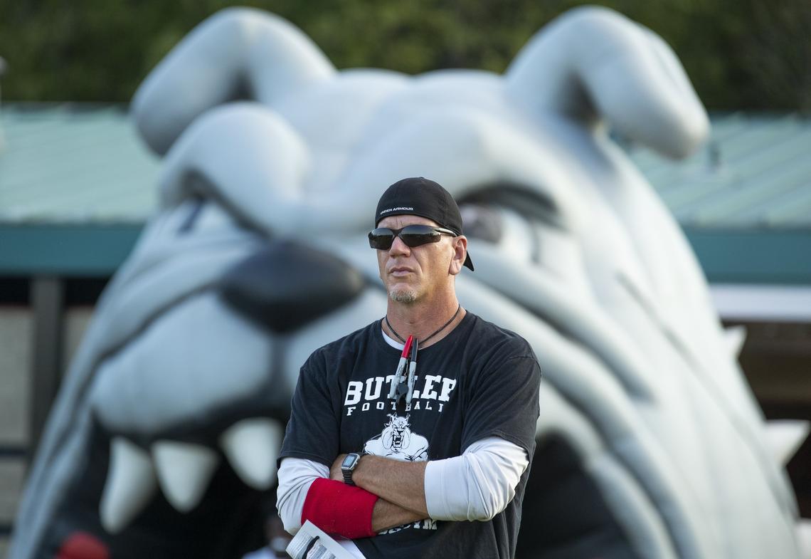 Butler head football coach Brian Hales watches his Bulldogs warm up before facing Myers Park at a prep football game at Butler High School Friday, October 5, 2018 in Matthews, NC. Photo by JASON E. MICZEK - Special to the Observer
