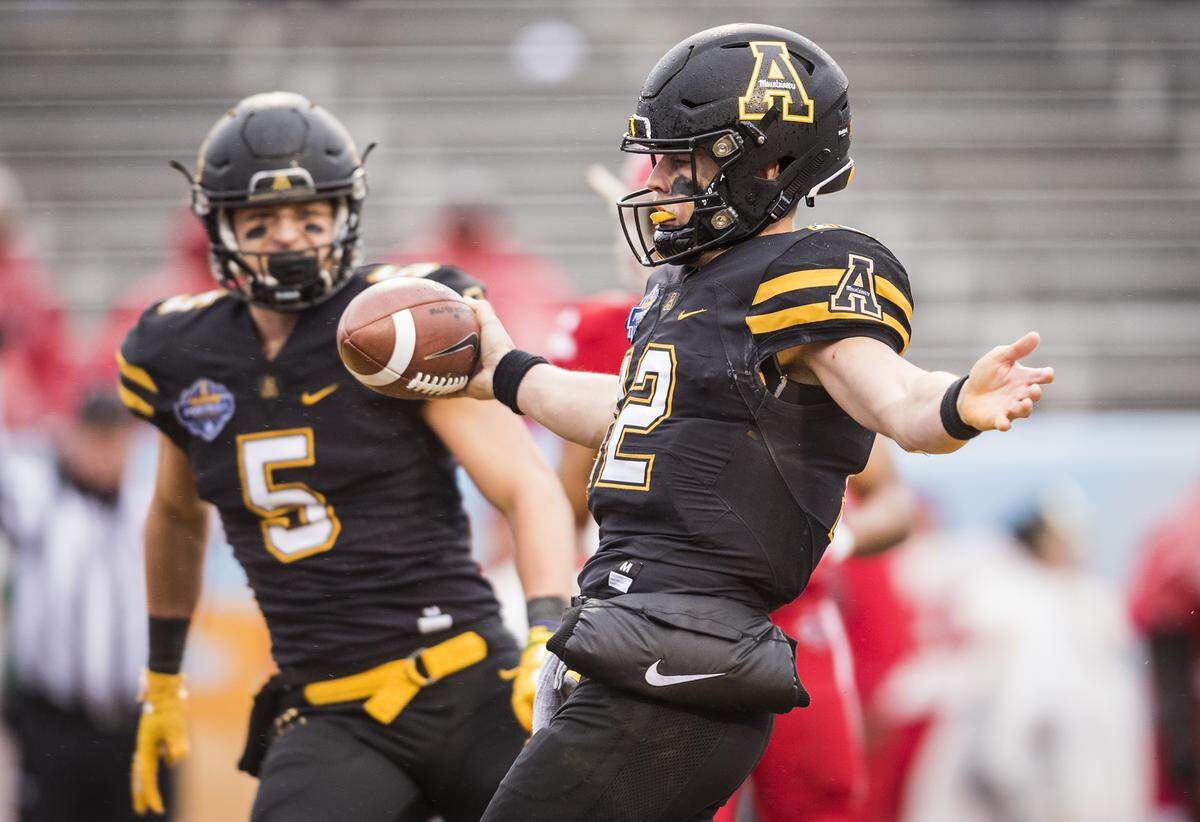 Appalachian State quarterback Zac Thomas (12) celebrates scores one of his two rushing touchdowns in the Sun Belt conference football championship game in Boone on Saturday. Appalachian State won 30-19.