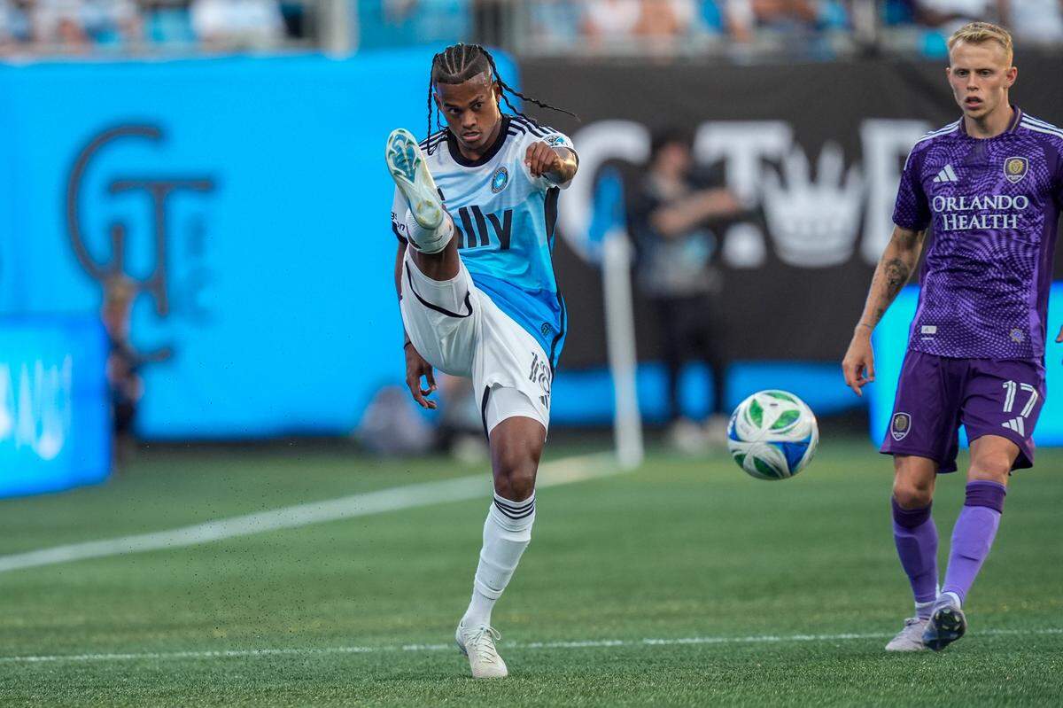 Jul 5, 2025; Charlotte, North Carolina, USA; Charlotte FC forward Kerwin Vargas (18) kicks the ball chased by Orlando City midfielder Dagur Thorhallsson (17) during the first half at Bank of America Stadium. Mandatory Credit: Jim Dedmon-Imagn Images