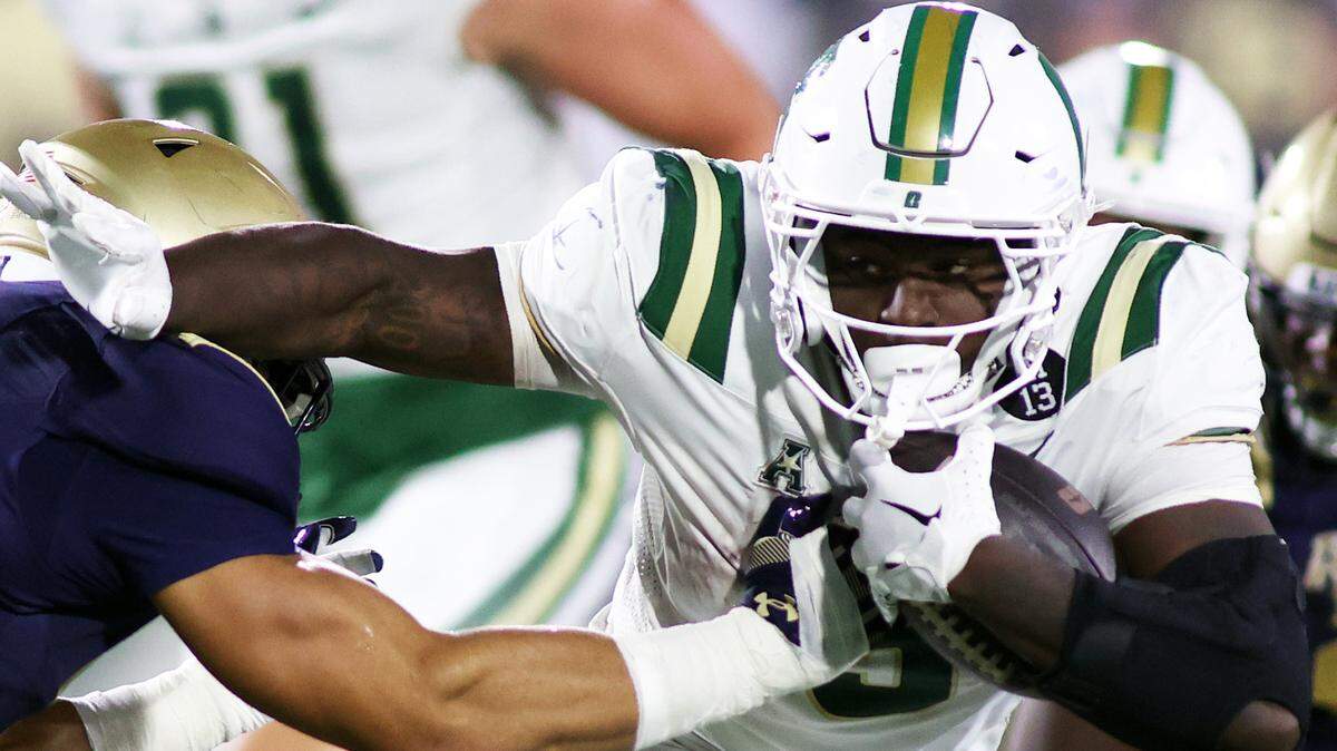 Oct 19, 2024; Annapolis, Maryland, USA; Charlotte 49ers running back Cartevious Norton (5) runs the ball against Navy Midshipmen linebacker Job Grant (39) during the second half at Navy-Marine Corps Memorial Stadium.
