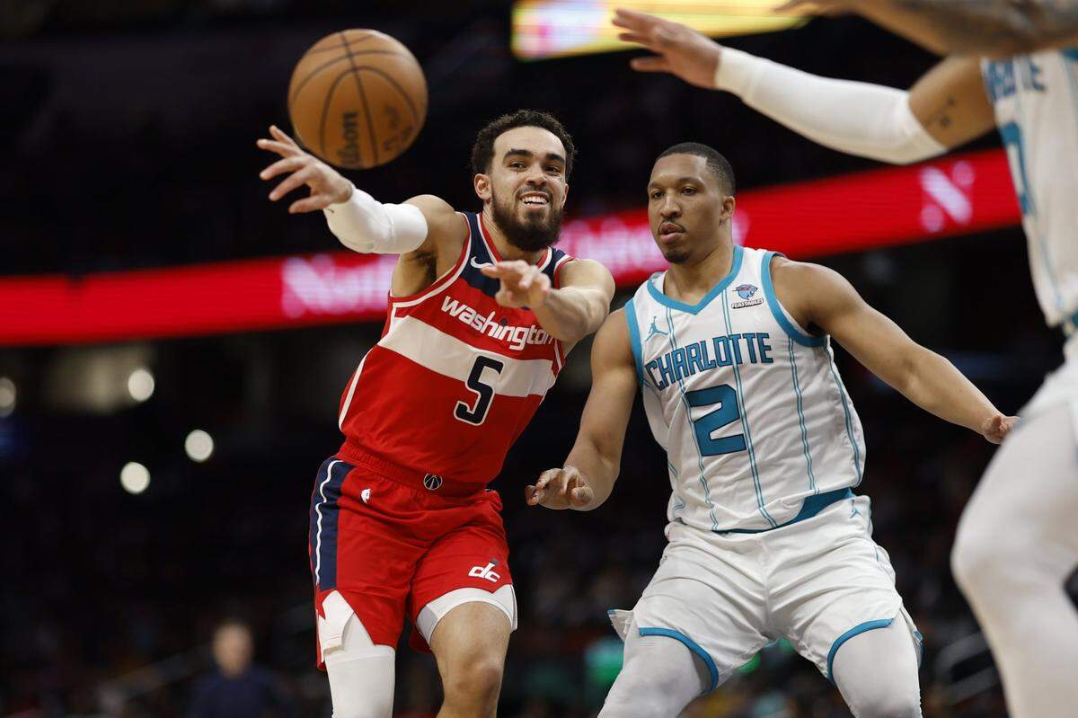 Washington Wizards guard Tyus Jones (5) passes the ball as Charlotte Hornets forward Grant Williams (2) defends in the first half at Capital One Arena. Mandatory Credit: Geoff Burke-USA TODAY Sports