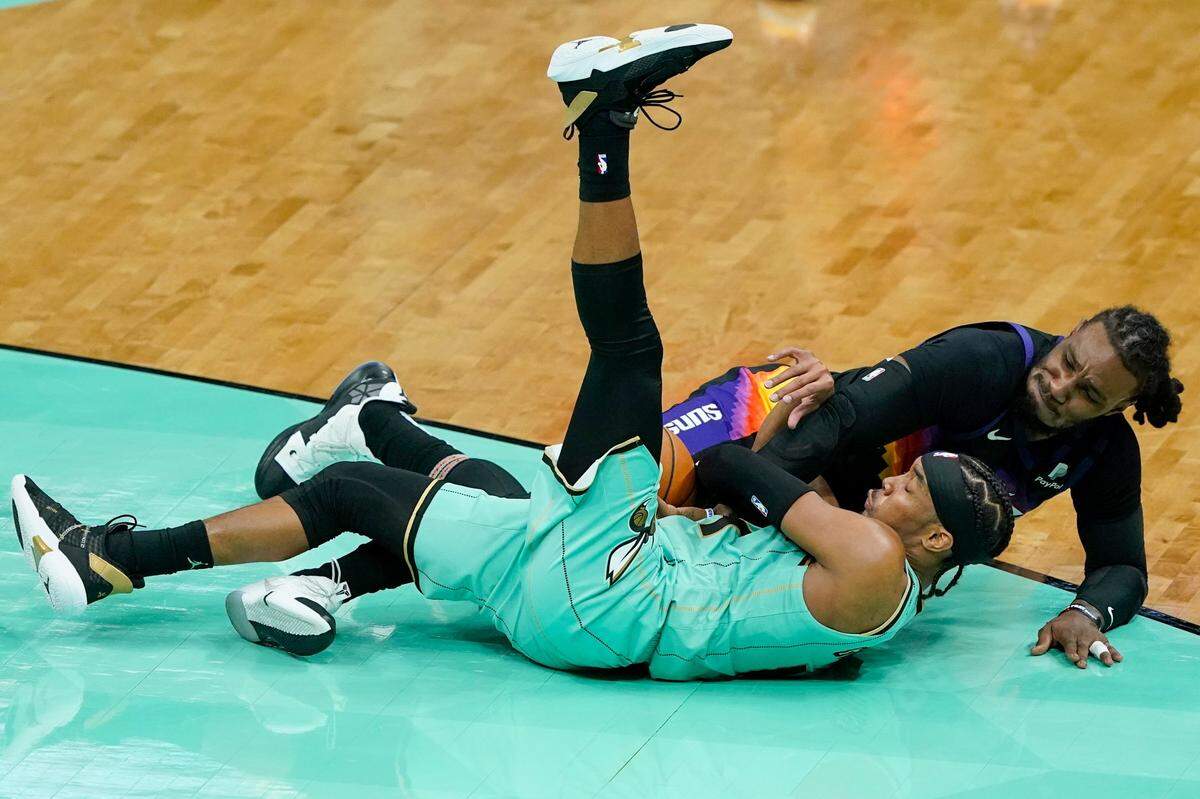 Charlotte Hornets guard Devonte Graham and Phoenix Suns forward Jae Crowder battle for a loose ball Sunday during the Suns’ 101-97 win.