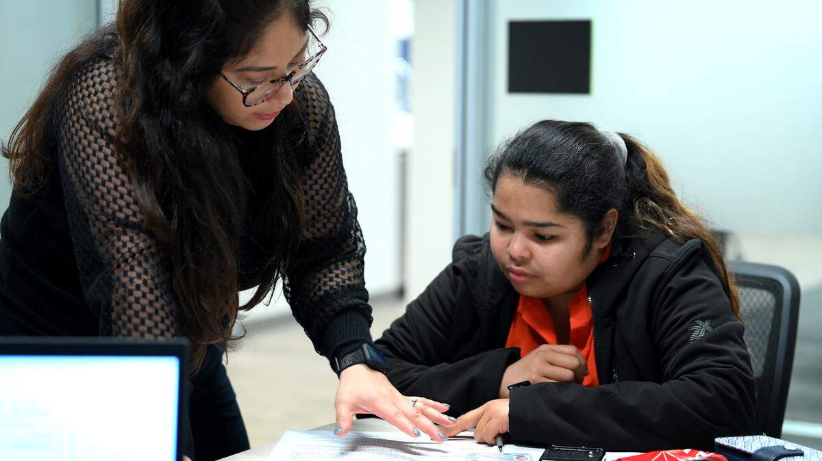 Kiara Vega, left, supervising attorney for Charlotte Center for Legal Advocacy, discusses paperwork with Erika Salamanca, right, at the center Friday, November 11, 2022. CCLA offers a one-day asylum clinic for immigrants and pairs them with lawyers to file their applications, which would increase their chance of success in gaining asylum.