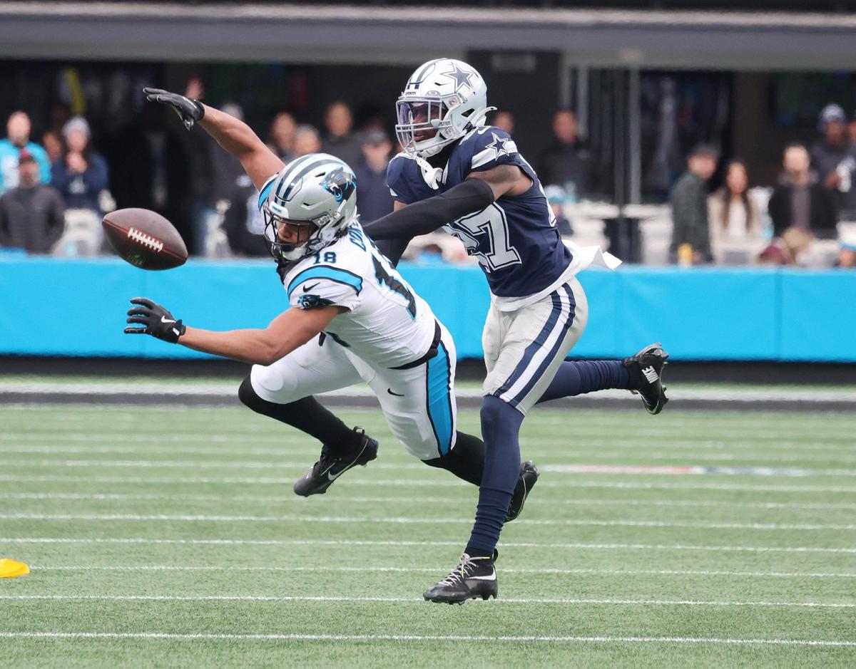 Panthers Jalen Coker reaches for the ball as Cowboys Amani Oruwariye defends Sunday at Bank of America Stadium.