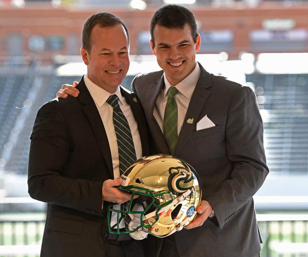 UNC Charlotte 49ers’ Director of Athletics Mike Hill, left, and new football coach Will Healy stop for a portrait with a helmet during Healy’s introductory news conference at Richardson Stadium on Wednesday, December 5, 2018.