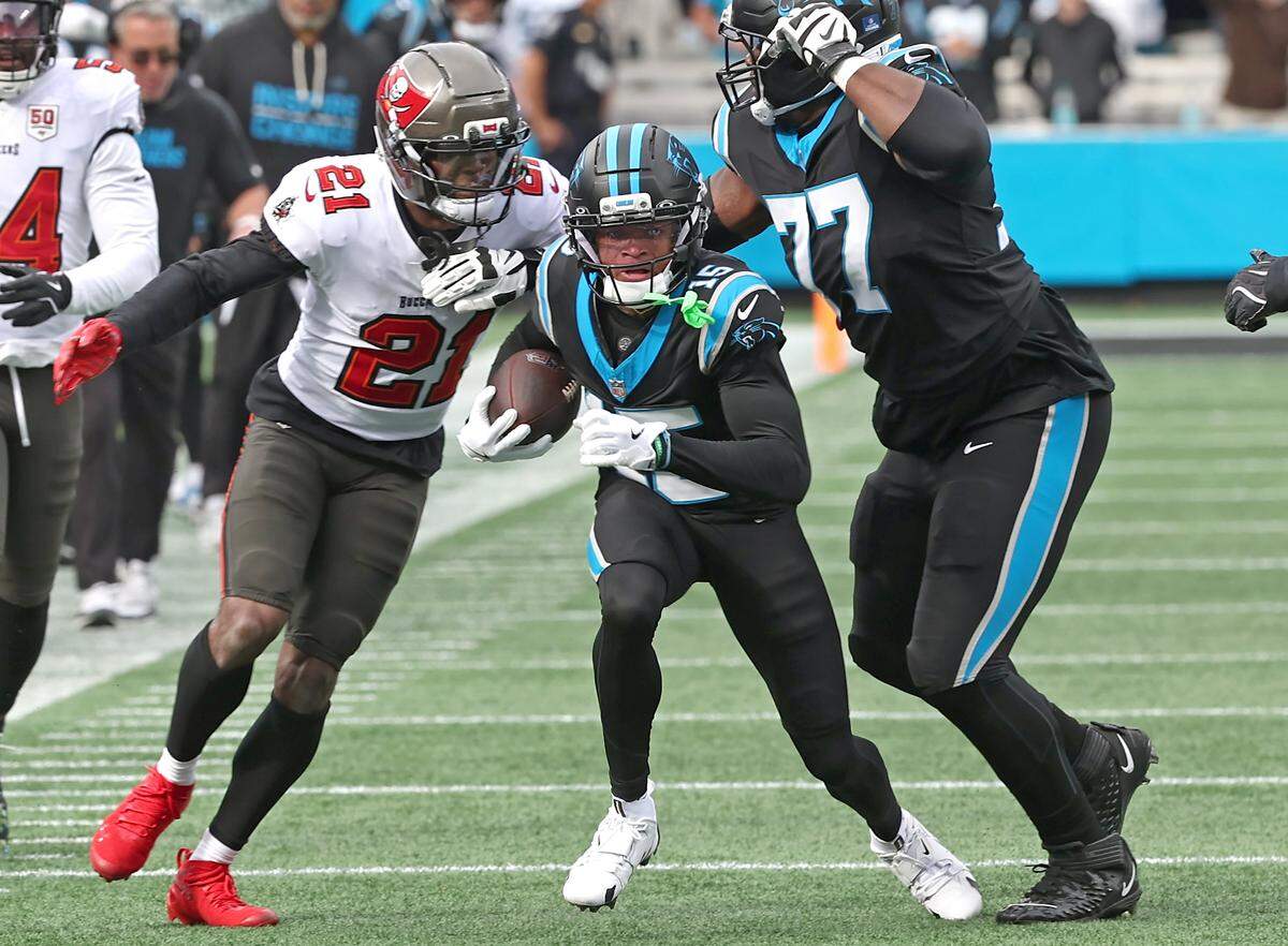 Carolina Panthers wide receiver Jimmy Horn Jr., center, runs between Tampa Bay Buccaneers cornerback Benjamin Morrison, left, and teammate/tackle Josh Nijman, right, during action on Sunday at Bank of America Stadium. The Panthers defeated the Buccaneers 23-20.