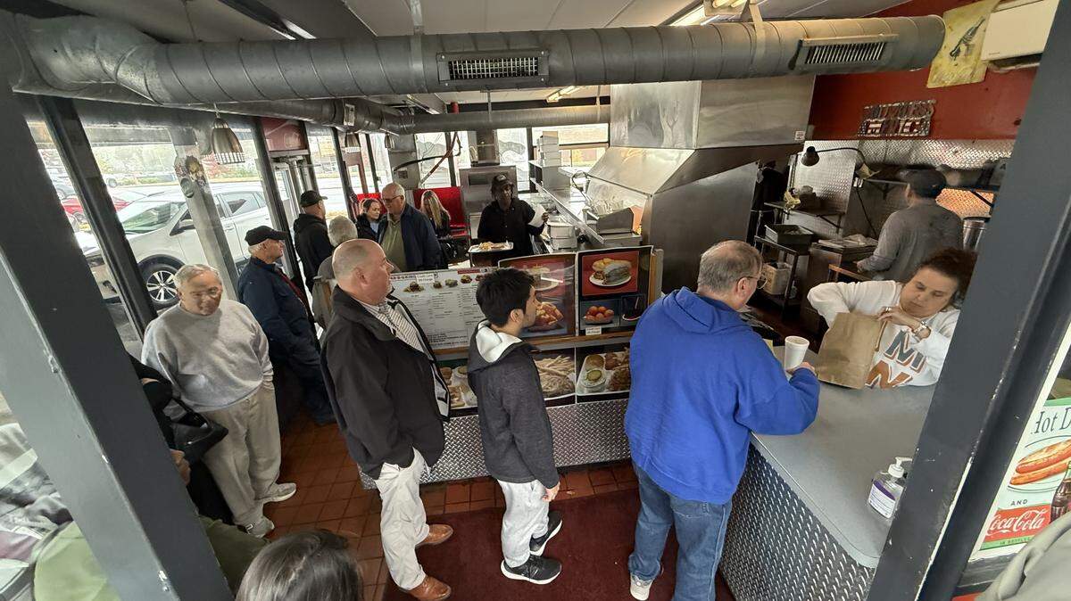 Inside Bar-B-Q King, the restaurant was packed as customers waited patiently in a long line to order at the counter on Wednesday, Oct. 29. A staff member at the register bags an order as the queue stretches back through the building, filled with patrons eager to say a final goodbye to the eatery, which will close on Nov. 1.