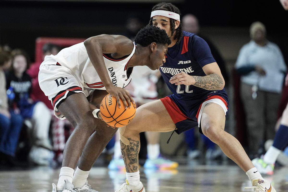 Davidson forward Manie Joses (0) is defended by Duquesne guard Maximus Edwards (22) during the first half of an NCAA college basketball game, Tuesday, Dec. 30, 2025, in Davidson, N.C.