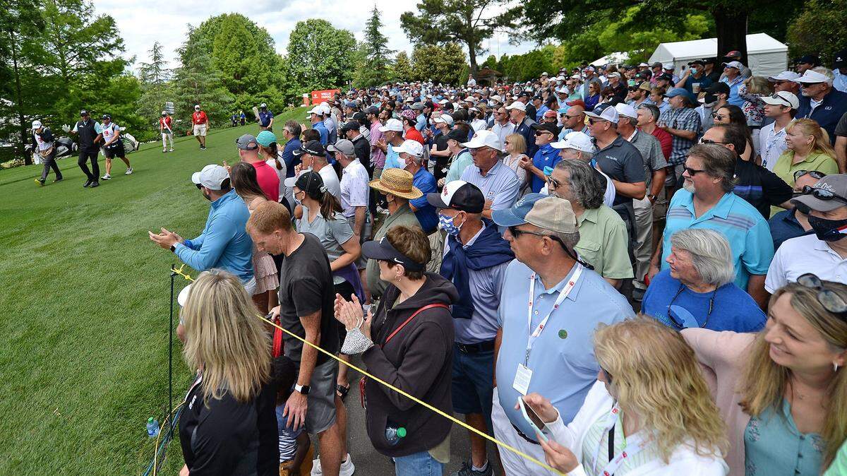 Golfer Phil Mickelson, left, waves to the fans near a crossing along the 16th fairway at Quail Hollow Club in Charlotte. The Presidents Cup will be held at Quail Hollow next year.