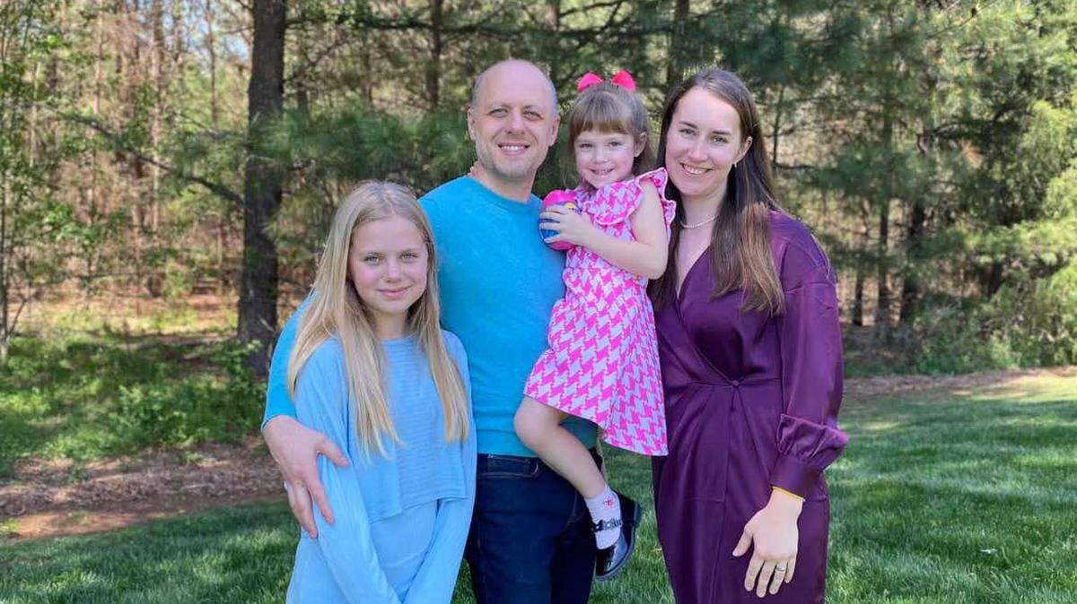 Slavik, 40, stands with his wife and two daughters. The family fled Ukraine to come to Charlotte almost three years ago to escape the war with Russia.
