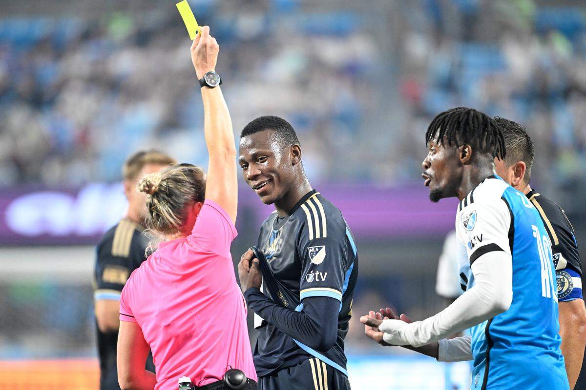 Referee Tori Penso gives a yellow card to Philadelphia Union midfielder Danley Jean Jacques (21) and Charlotte FC forward Wilfried Zaha (10) in the first half at Bank of America Stadium. 