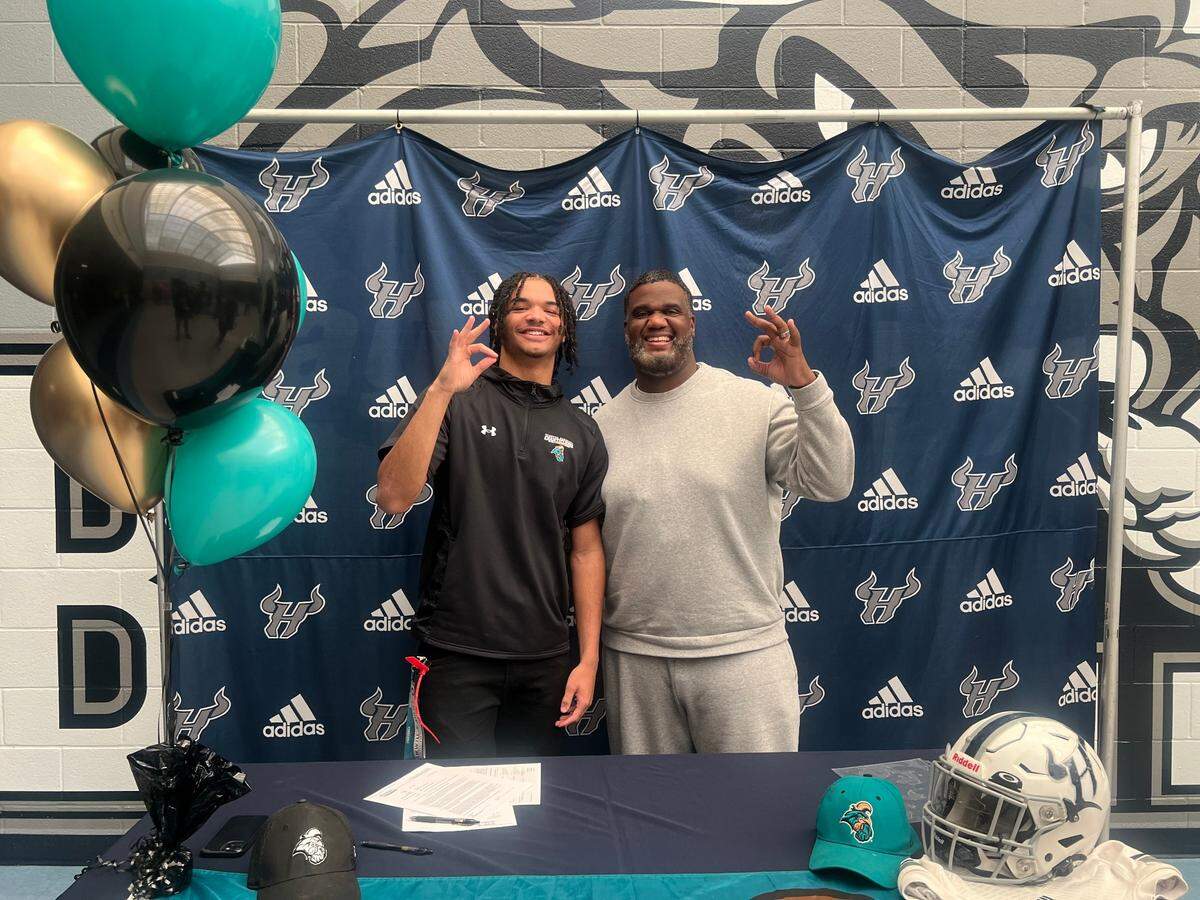 Hickory Ridge wide receiver Jalen Harris, seen here with head coach Jupiter Wilson, signed with Coastal Carolina Wednesday