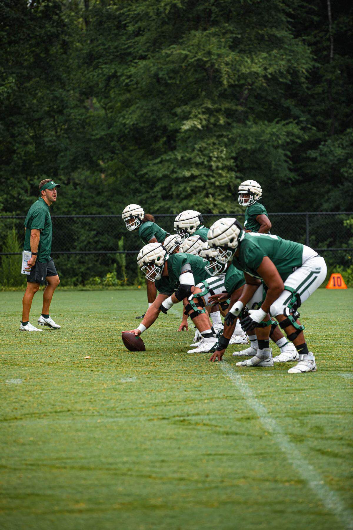 The Charlotte 49ers offensive line gets set to run a play during preseason workouts recently.