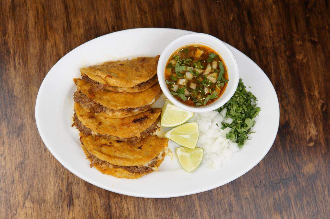 At Tacos El Peladito, four birria tacos come with a side of cilantro, onions and consomme. The tortillas are marinated with the same consommé provided, giving it that famous orange look, before they’re stuffed with melted cheese and barbacoa.