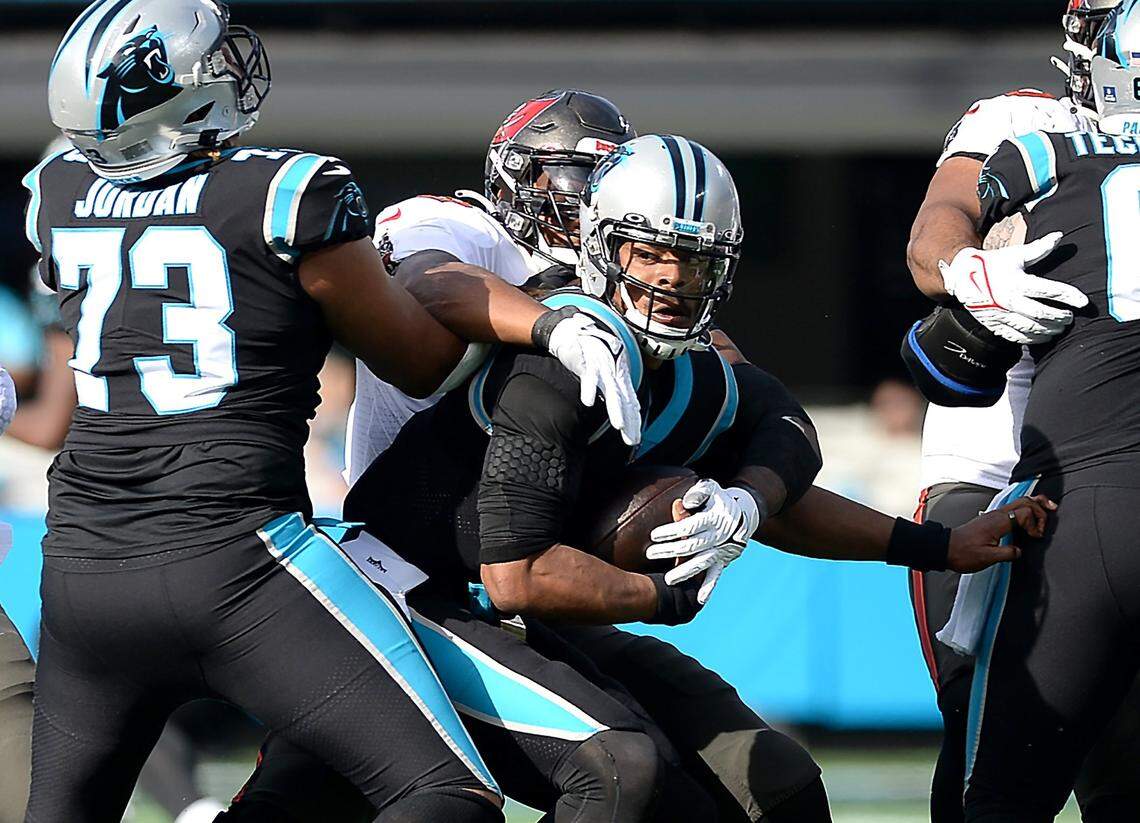 Carolina Panthers quarterback Cam Newton, center, is sacked by Tampa Bay Buccaneers defensive lineman William Gholston during first quarter action on Sunday, December 26, 2021 at Bank of America Stadium in Charlotte, NC.